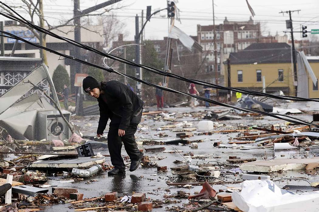 A man walks through storm debris following a deadly tornado Tuesday, March 3, 2020, in Nashvill ...
