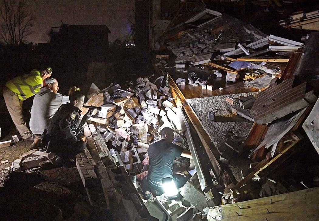 Rescue workers work to free Bill and Shirley Wallace from their home that collapsed and trapped ...
