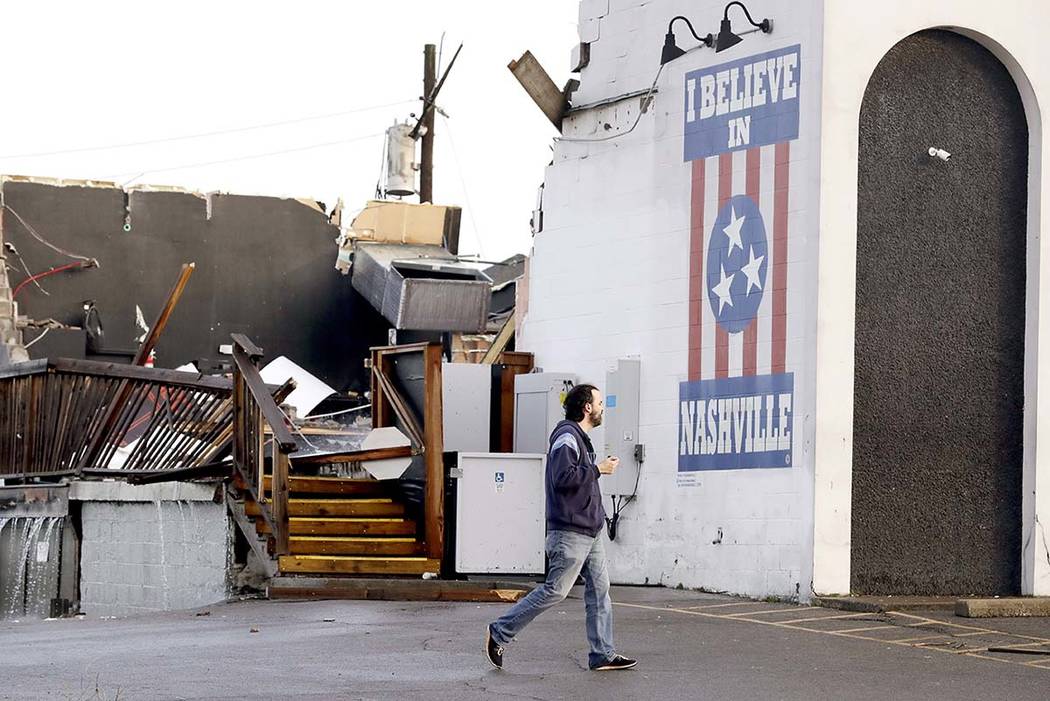 A man walks by The Basement East, a live music venue destroyed by storms Tuesday, March 3, 2020 ...