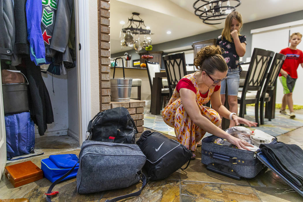 Holly Steed checks on some of the supplies in their 72-hour emergency bags stored in the hall c ...