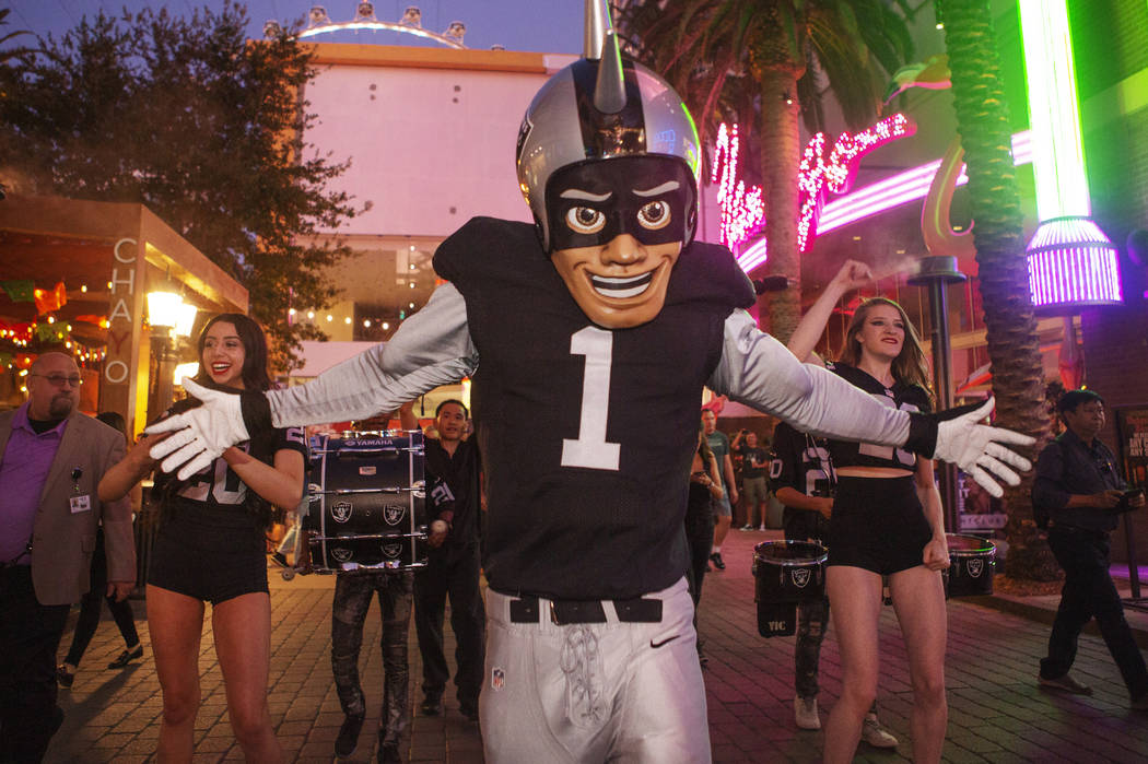 The Raiders mascot celebrates with Diana Tatevossian, left, and Kayla Kalisz, right, of Extreme ...