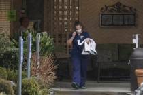 A worker at the Life Care Center in Kirkland, Wash., near Seattle, wears a mask as she leaves t ...