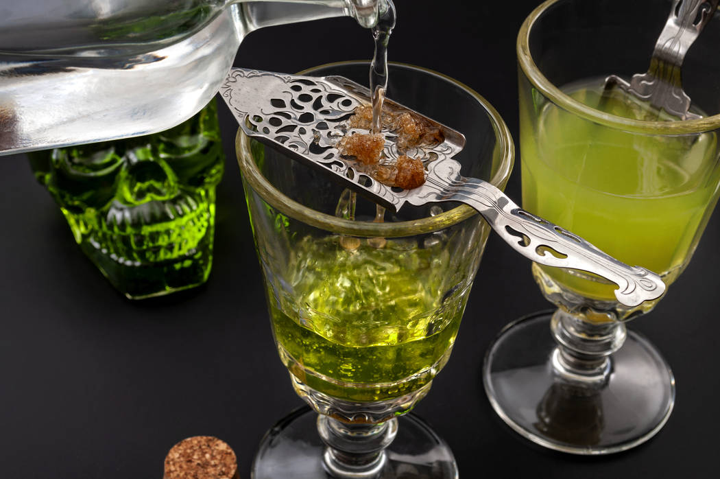 Alcohol, the green fairy and dangerous liquor conceptual idea with crystal glasses of absinthe, ...