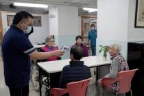 Elderly women receive temperature checks in a nursing home in Hong Kong, Friday, Feb. 14, 2020. ...