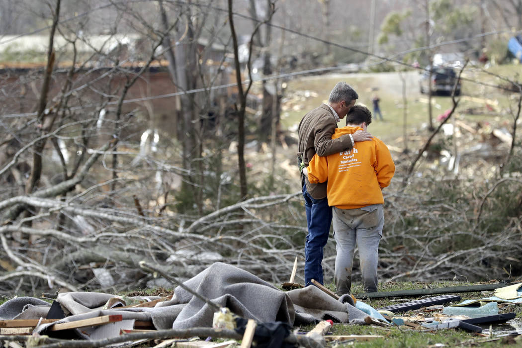 Tennessee Gov. Bill Lee, left, prays with Kayla Cowen, right, as Cowen looks through rubble in ...