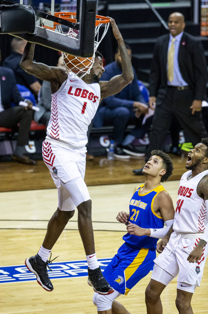 New Mexico Lobos forward Corey Manigault (1, above) dunks over San Jose State Spartans guard Ka ...