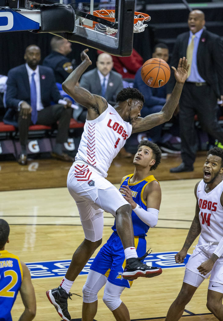 New Mexico Lobos forward Corey Manigault (1, above) dunks over San Jose State Spartans guard Ka ...
