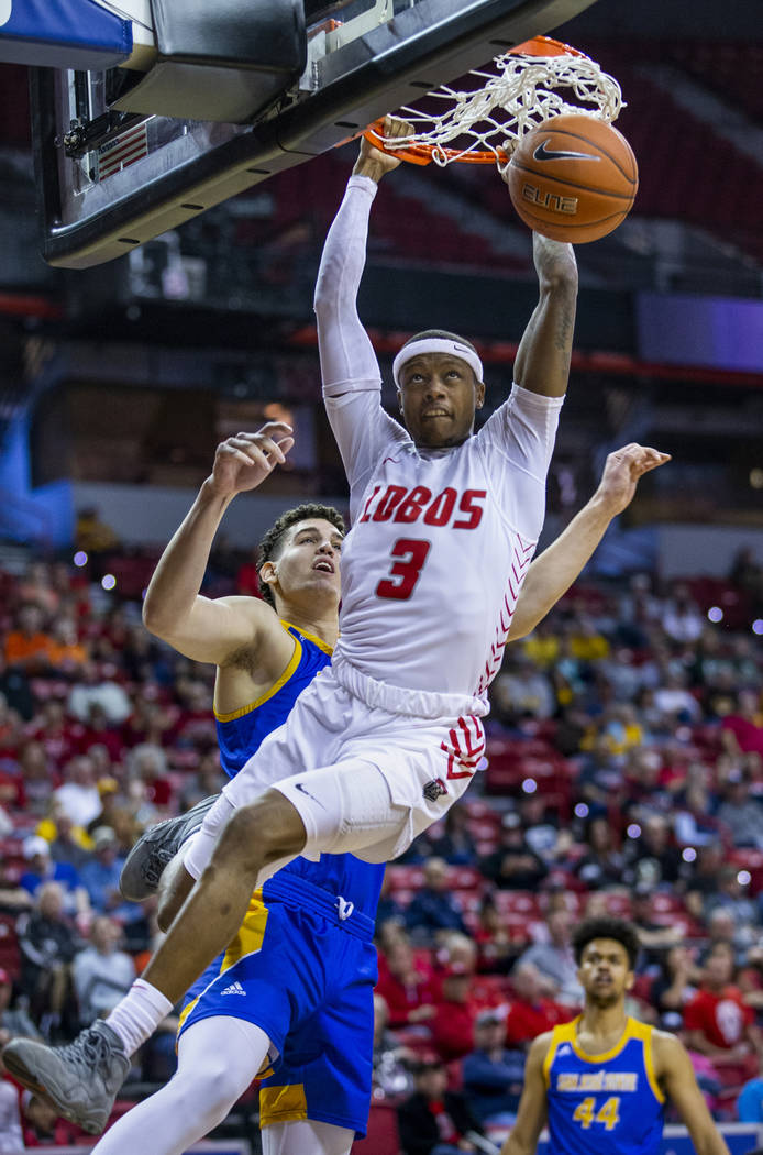 New Mexico Lobos guard Keith McGee (3, right) dunks after beating San Jose State Spartans forwa ...