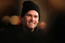 New England Patriots quarterback Tom Brady smiles while answering a question during the NFL foo ...