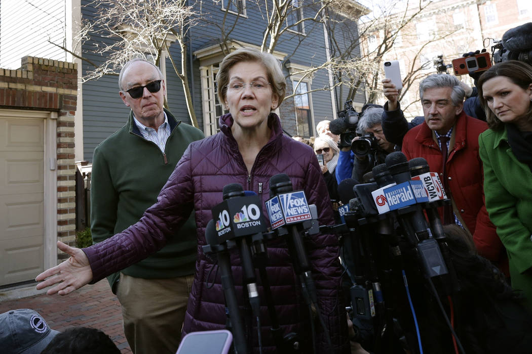 Sen. Elizabeth Warren, D-Mass., with her husband Bruce Mann beside her, speaks to the media out ...