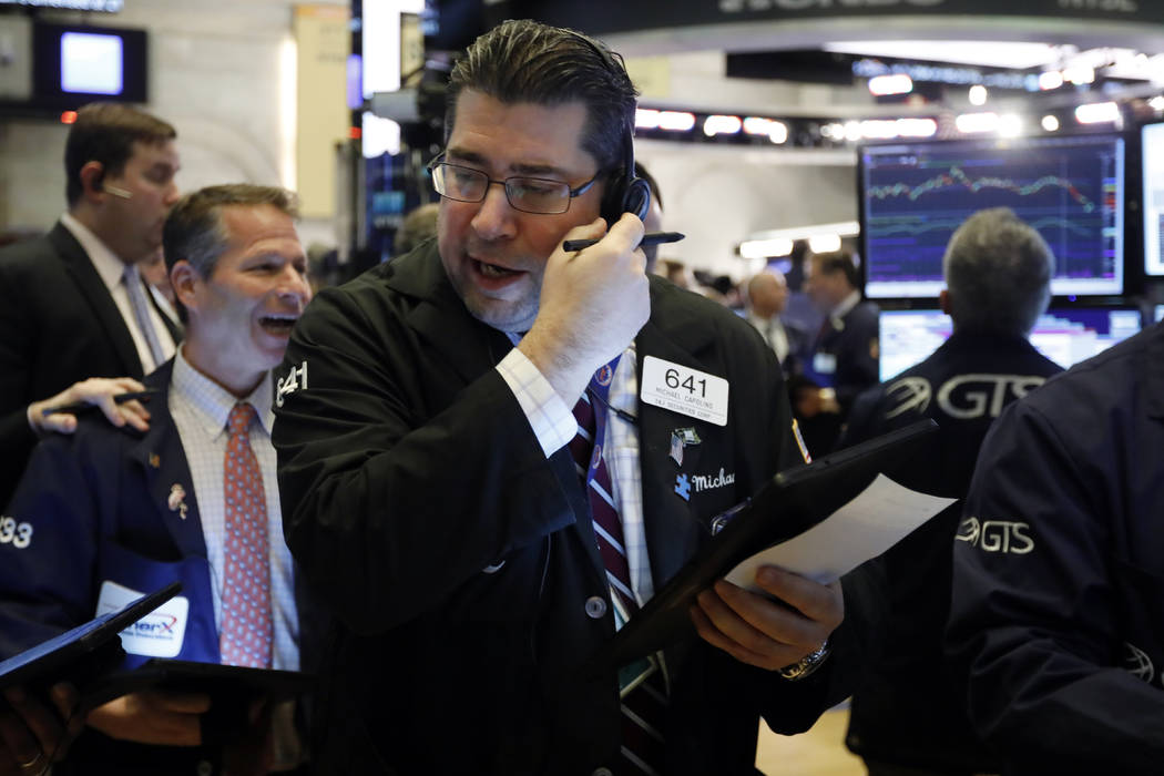 Trader Michael Capolino, center, works on the floor of the New York Stock Exchange, Thursday, M ...