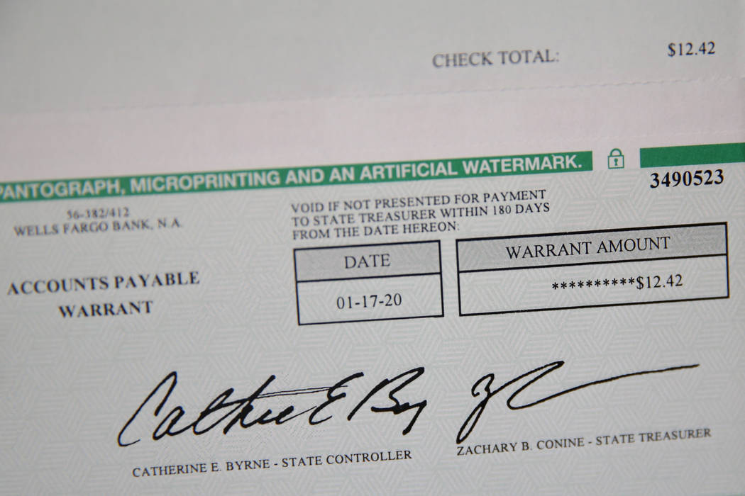 Scott Garner shows a restitution payment he received at his home in Henderson, Saturday, March ...