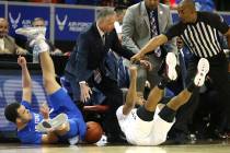Air Force's Sid Tomes, left, and San Diego State's KJ Feagin slide off the court chasing a loos ...