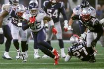 Tennessee Titans running back Derrick Henry runs from New England Patriots defenders in the fir ...