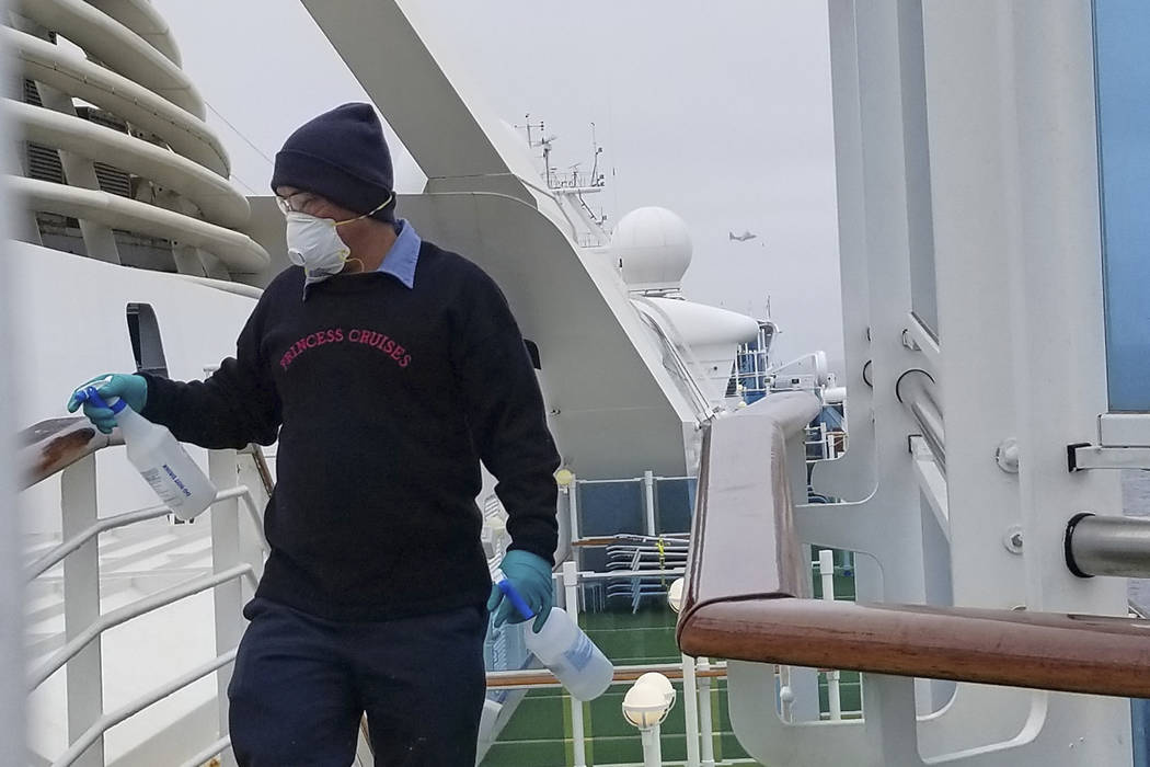 In this photo provided by Michele Smith, a cruise ship worker cleans a railing on the Grand Pri ...