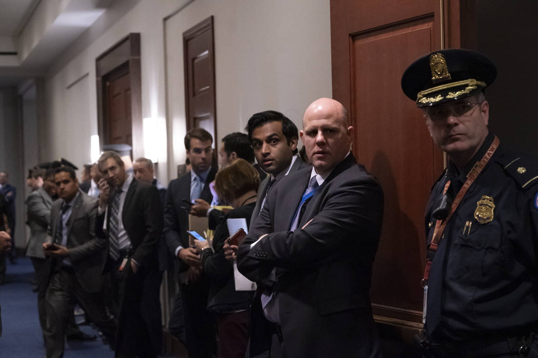 Police, press, and congressional staff wait outside a closed-door meeting between members of th ...