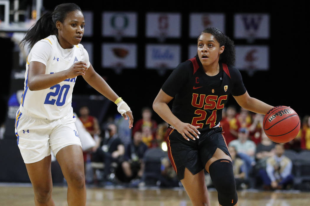 Southern California's Desiree Caldwell (24) drives around UCLA's Charisma Osborne (20) during t ...