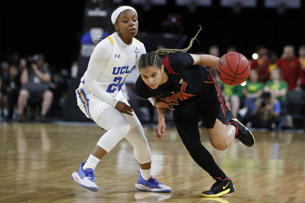 Southern California's Endyia Rogers (4) drives around UCLA's Japreece Dean (24) during the firs ...