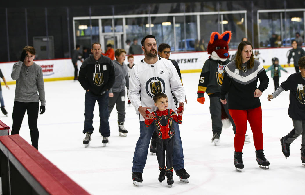 Zach Montgomery, of Las Vegas, helps his son, Michael, 5, skate on the ice at City National Are ...