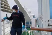 A cruise ship worker cleans a railing on the Grand Princess Thursday, March 5, 2020, off the Ca ...