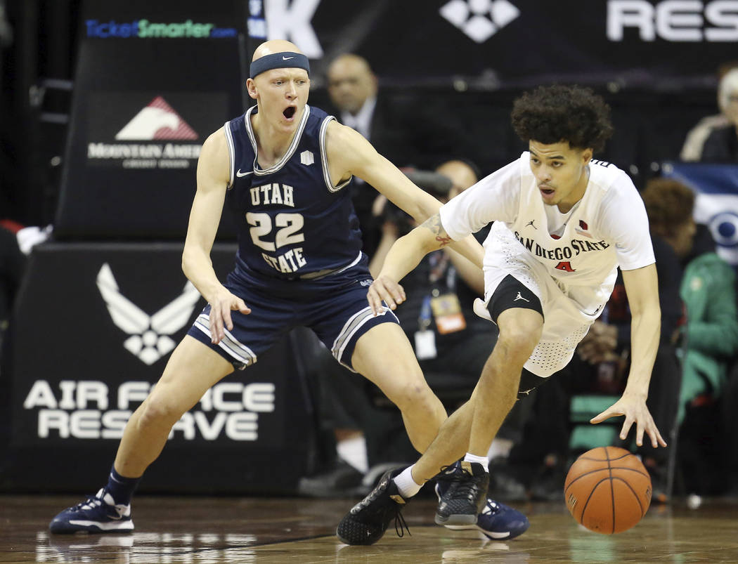 San Diego State's Trey Pulliam (4) drives as Utah State's Brock Miller (22) defends during the ...