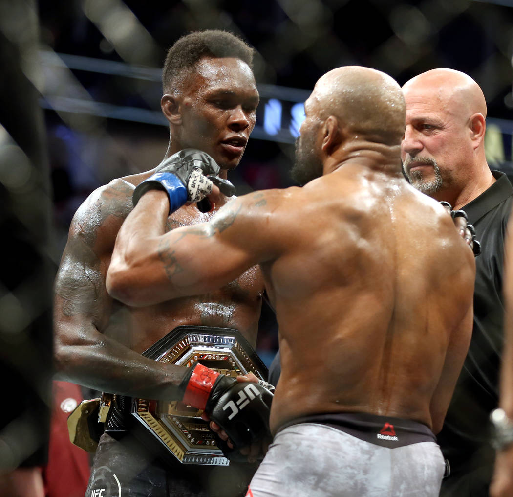 Middleweight Israel Adesanya , left, and Yoel Romero come together after Ad...