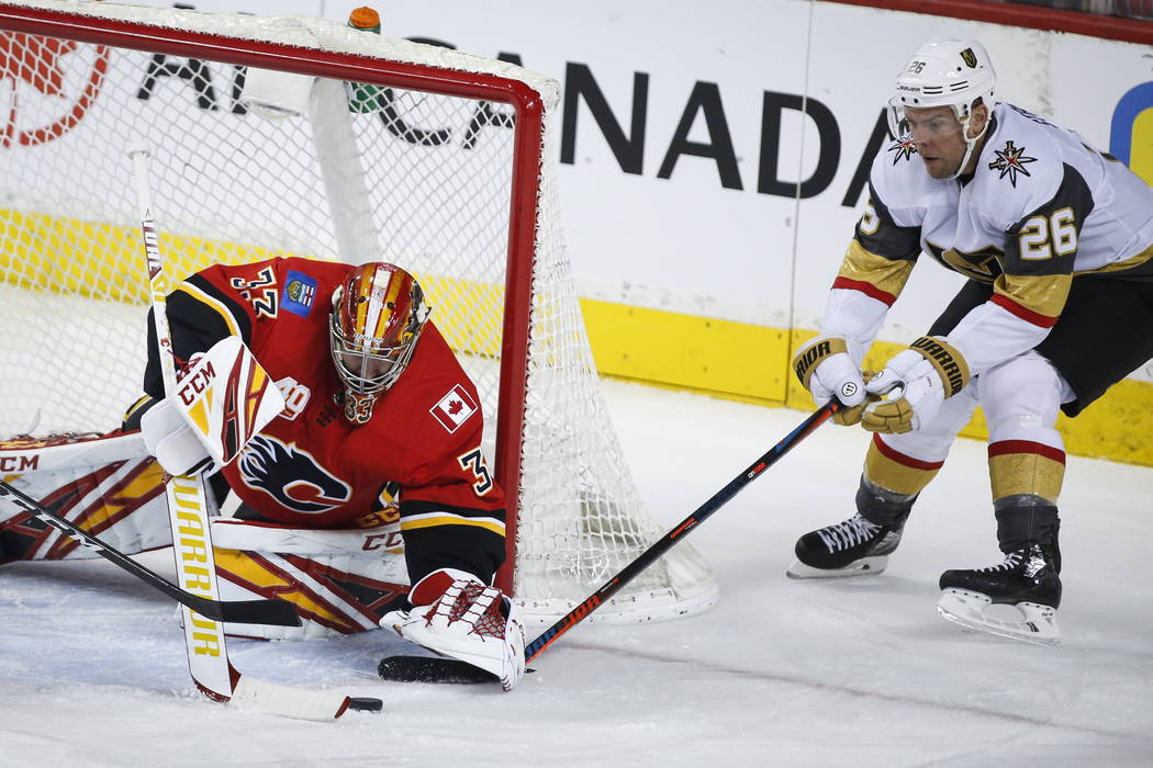 Vegas Golden Knights' Paul Stastny, right, tires to get the puck before Calgary Flames goalie D ...