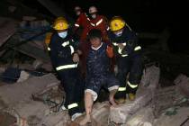 Rescuers help a man from the rubble of a collapsed hotel building in Quanzhou city in southeast ...
