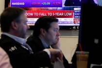 A television screen headlines news as traders prepare for the day's activity on the floor of th ...