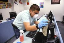 Custodian Kyle Brehm disinfects surfaces at Spring Valley High School in Las Vegas Monday, Marc ...