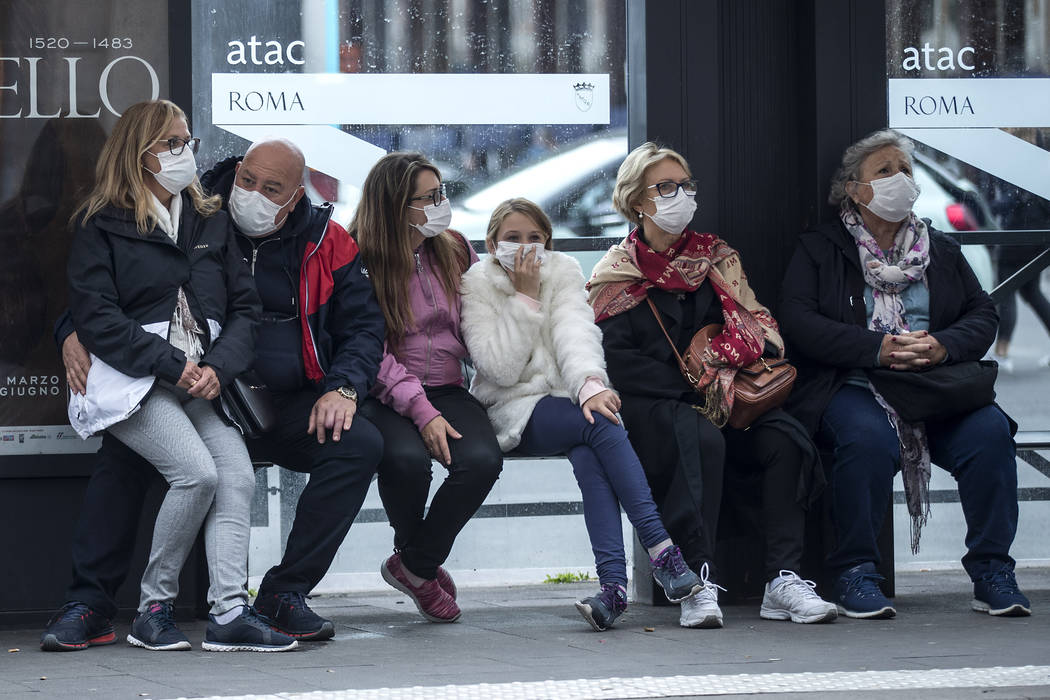 People wait at a bus stop, in Rome, Monday, March 9, 2020. Italy announced a sweeping quarantin ...