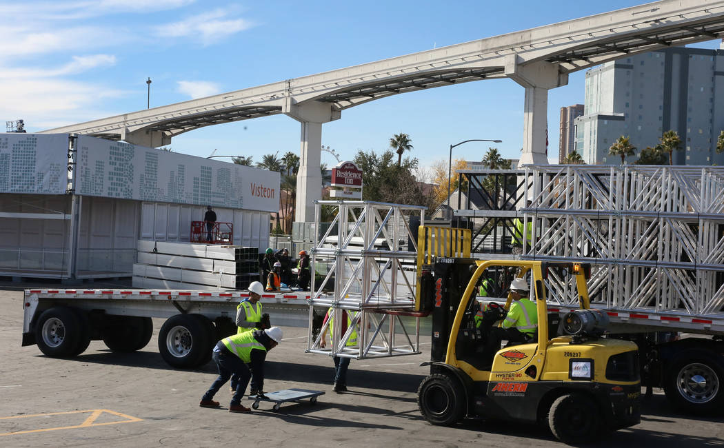 Workers from Pavillon Event Service unload construction equipments next to the Visteon's, a glo ...