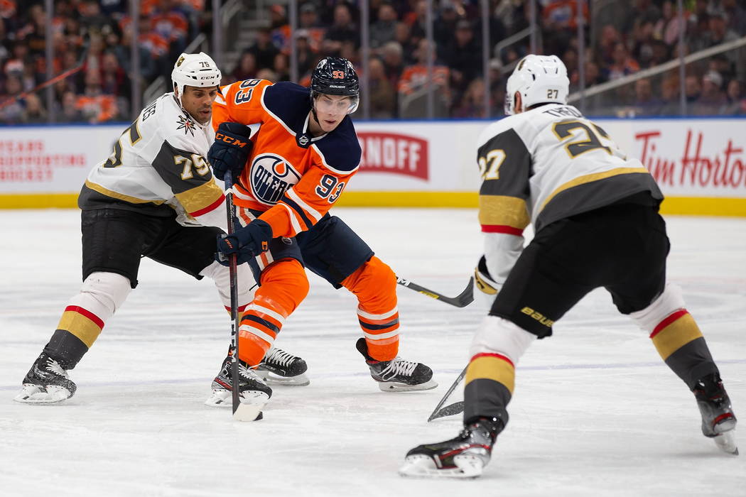 Edmonton Oilers' Ryan Nugent-Hopkins (93) is watched by Vegas Golden Knights' Ryan Reaves (75) ...