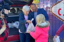 Serving Our Kids Foundation volunteer Sue Lindhout delivers the agency's 500,000th food bag to ...