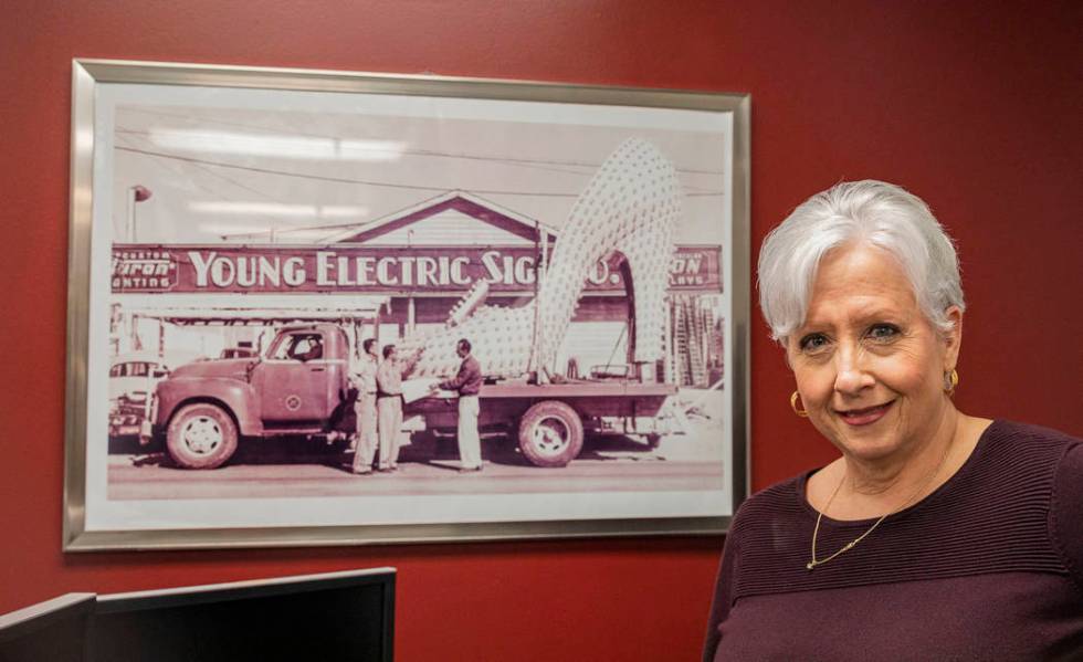 Administrative assistant for Yesco Karin Tomanio stands next to a photograph of her grandfather ...