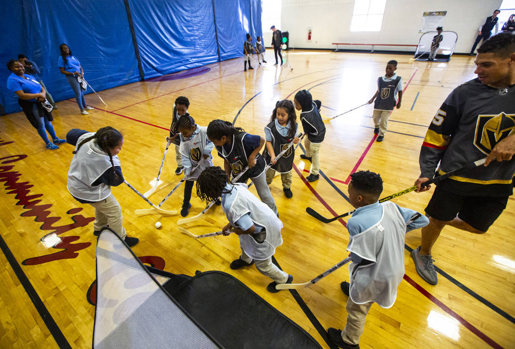 Children vie for the ball during a youth street hockey clinic at Doolittle Recreation Center in ...