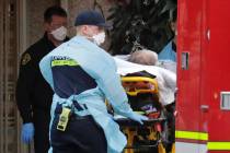 A patient is loaded into an ambulance, Tuesday, March 10, 2020, at the Life Care Center in Kirk ...