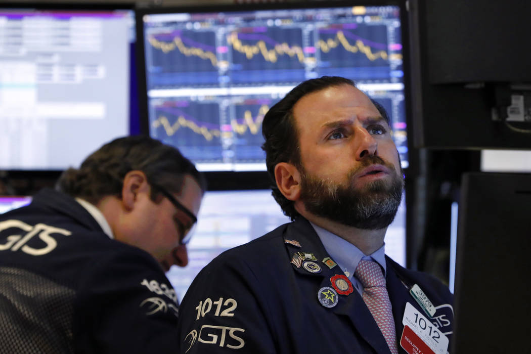 Specialist Michael Pistillo. right, works on the floor of the New York Stock Exchange, Wednesda ...