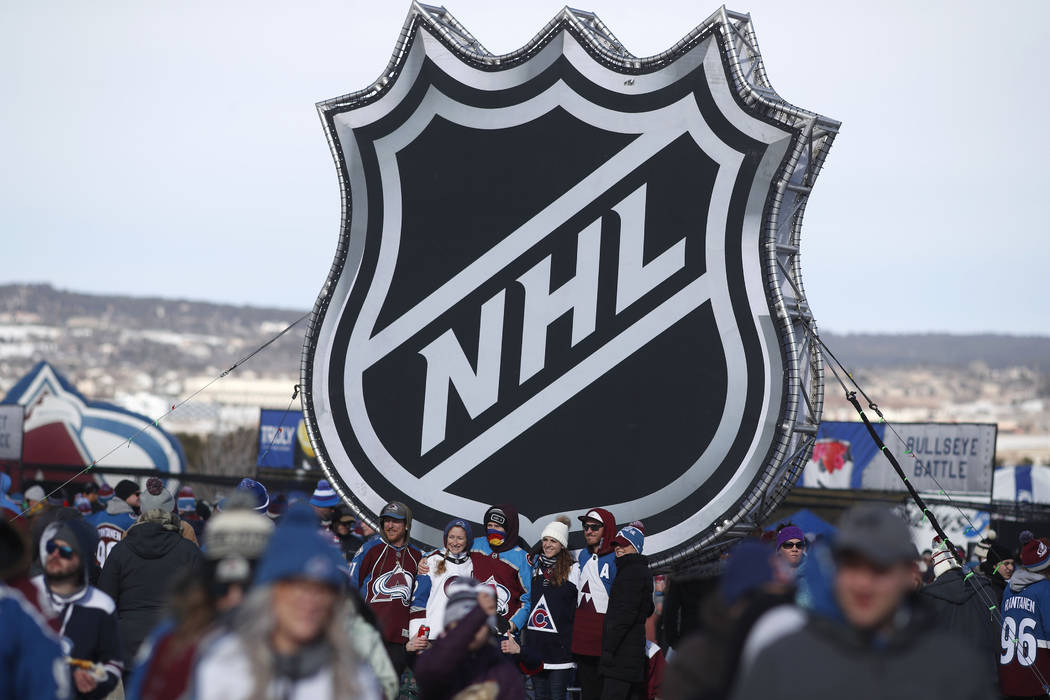 Fans pose below the NHL league logo at a display outside Falcon Stadium before an NHL Stadium S ...
