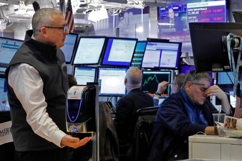 A trader uses a hand sanitizer dispenser on the floor of the New York Stock Exchange, Thursday, ...