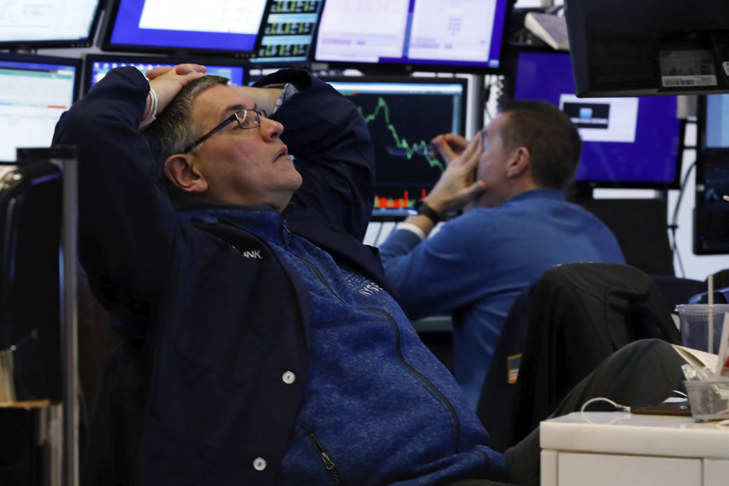 A pair of traders work in their booth on the floor of the New York Stock Exchange, Thursday, Ma ...