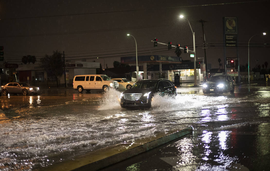 Cars pass through the intersection of East Sahara Avenue and South Eastern Avenue after heavy r ...