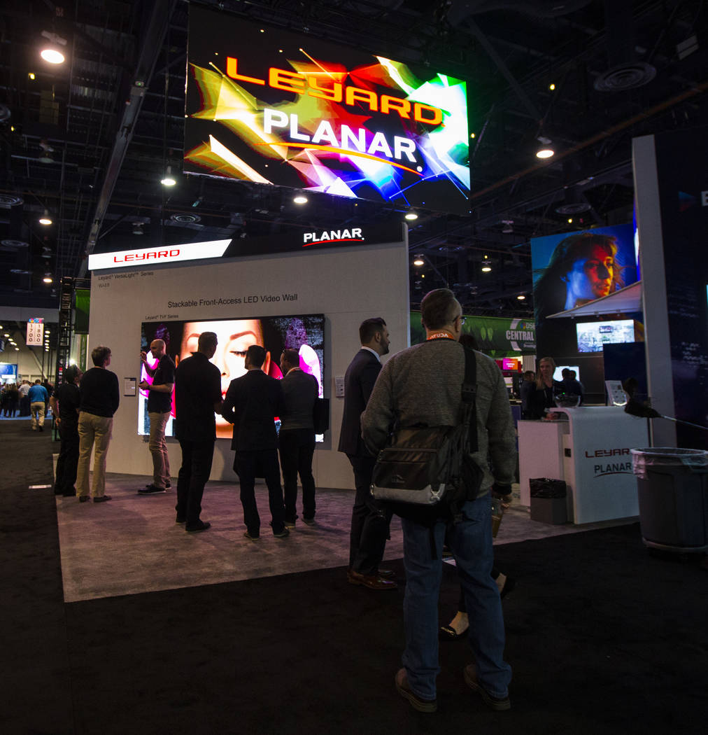 Attendees walk by the Leyard and Planar booth at the Digital Signage Expo at the Las Vegas Conv ...