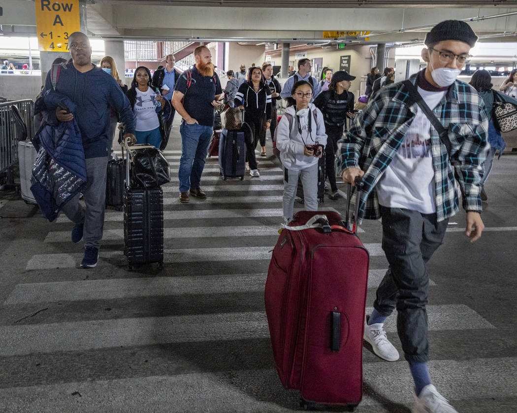 Passengers walk to the ride-hailing service area at McCarran International Airport in Las Vegas ...