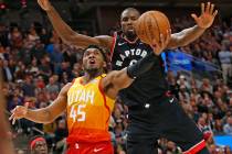 Toronto Raptors center Serge Ibaka, rear, defends against Utah Jazz guard Donovan Mitchell (45) ...