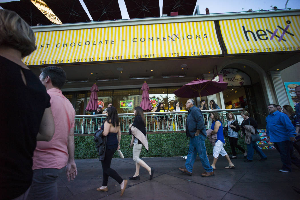 People pass Hexx restaurant outside of the Paris hotel-casino in Las Vegas on Friday, Nov. 4, 2 ...