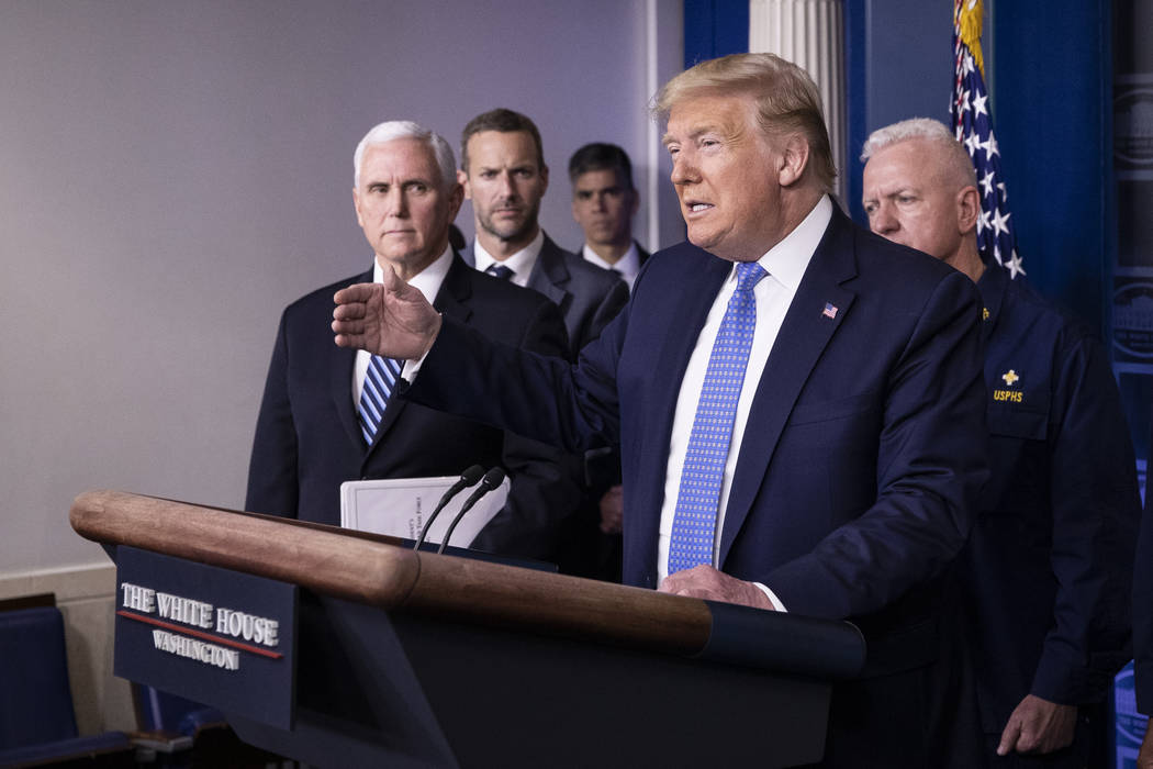 President Donald Trump, accompanied by Vice President Mike Pence, left, speaks during a briefin ...