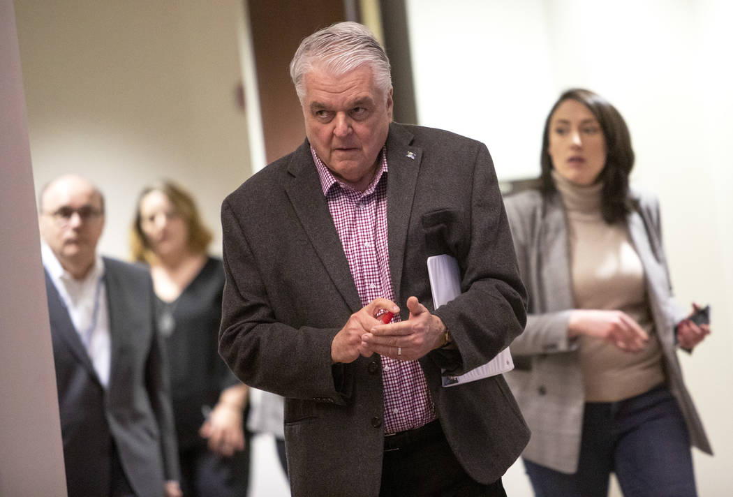 Gov. Steve Sisolak uses hand sanitizer as he walks to the podium to give remarks on the COVID-1 ...