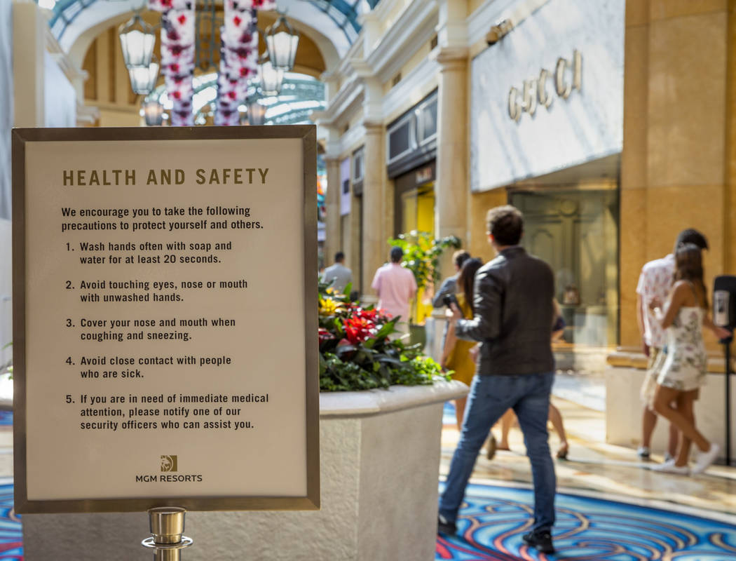 Health and safety guidelines greet visitors entering the shops at the Bellagio along the Strip ...