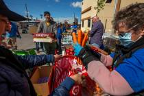 Christina Bailey, right, helps distribute carrots to those in need at SHARE Village Las Vegas o ...